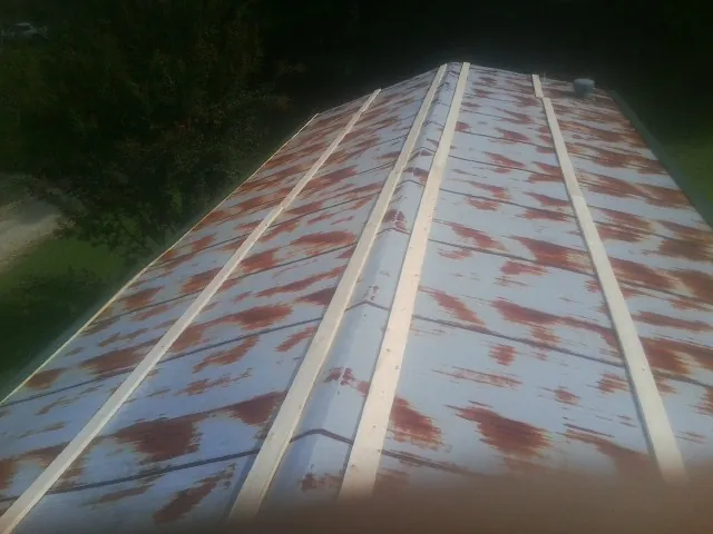 Rusted metal roof panels with new wood purlins before replacement — Storm Damage Roof Repair in Braman by Roofing Brothers