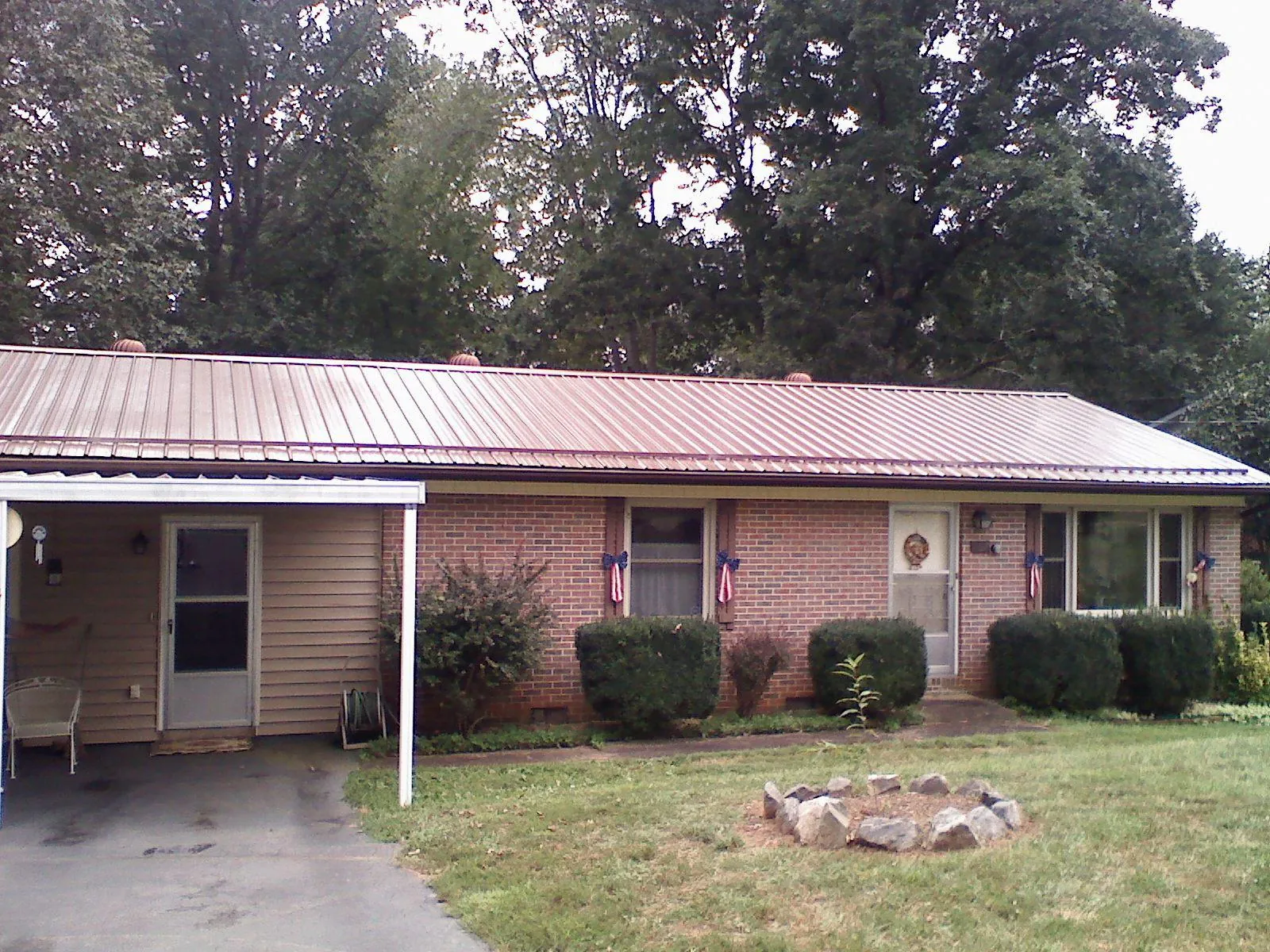 Bronze metal roof and carport on a brick ranch home — Roof Repair work by our crew in Braman
